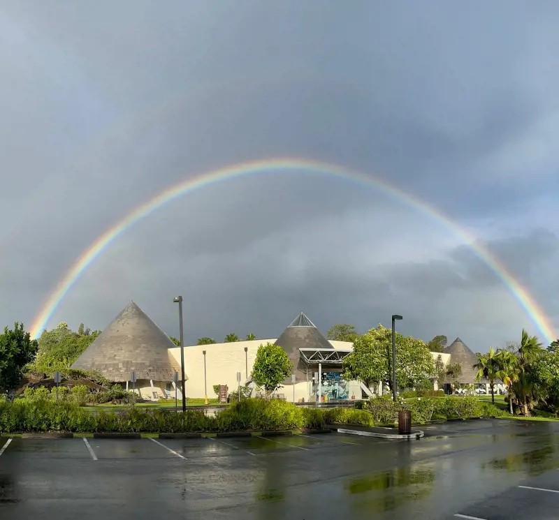 A beautiful shot of the Imiloa Astronomy Center and a rainbow in the background