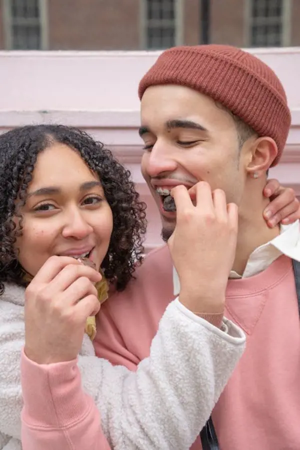 A young couple feeding eachother chocolate