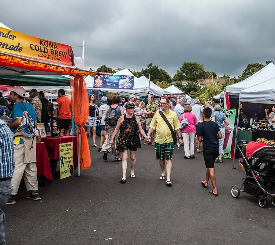 A busy area of the Kona Farmers Market filled with customers at different vendors
