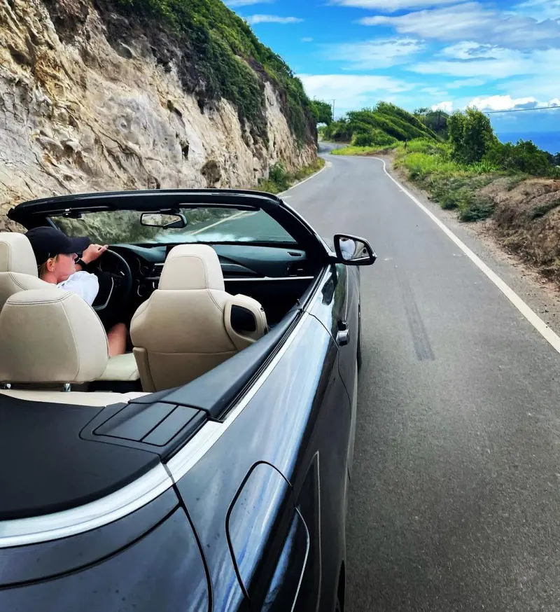 A traveler driving through a scenic route in a convertible