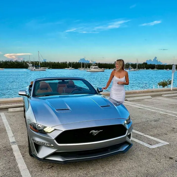A lady stand beside the Mustang Convertible