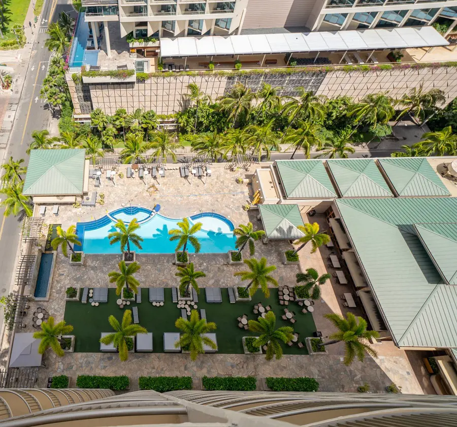 A view of the outdoor pool and lounges at Embassy Suites Waikiki Beach Walk from the terrace