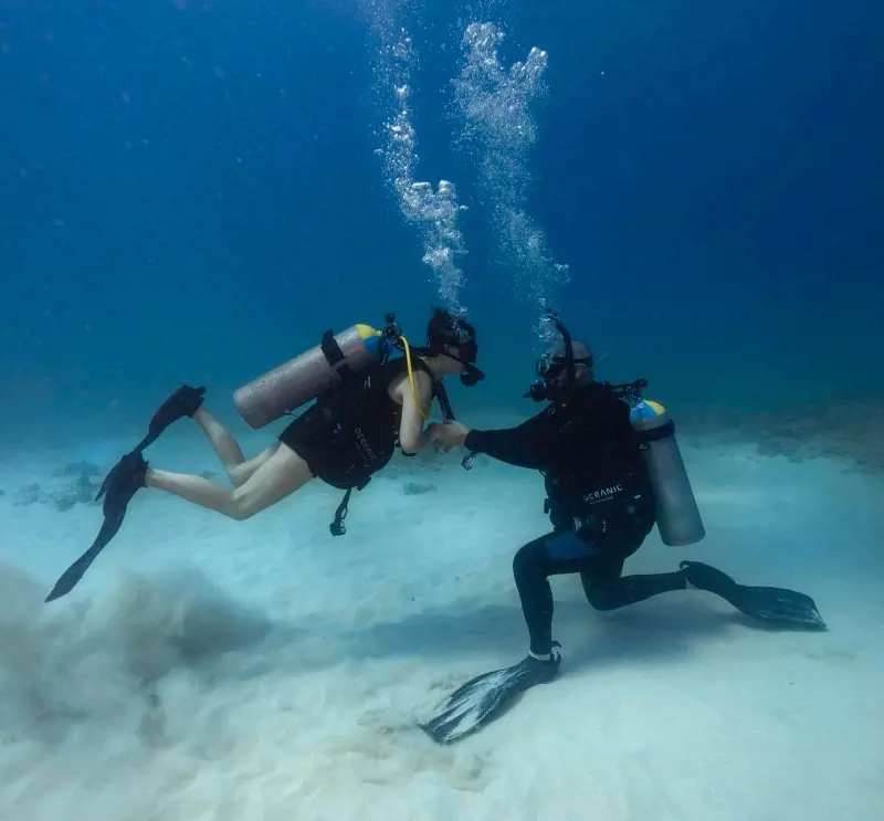 A young diver learning scuba diving skills from an expert