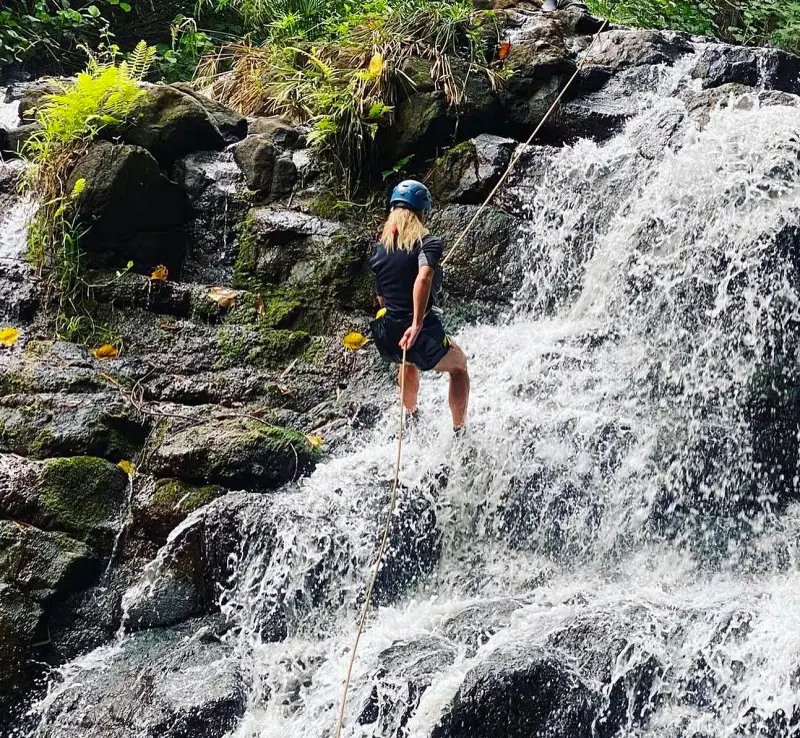 A lady enjoys waterfall rapple in Hawaii