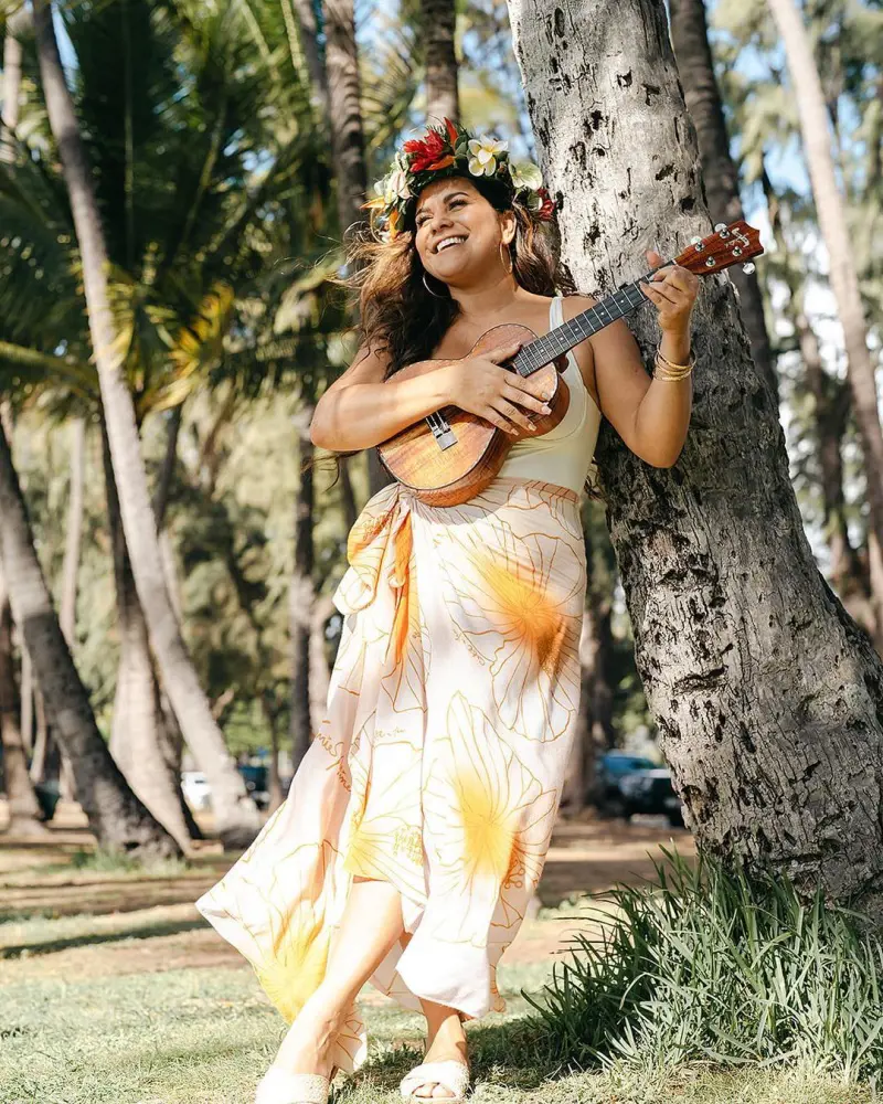 Kimie in a cool outfit playing ukulele on a beautiful premise of Hilo Seaside Hotel