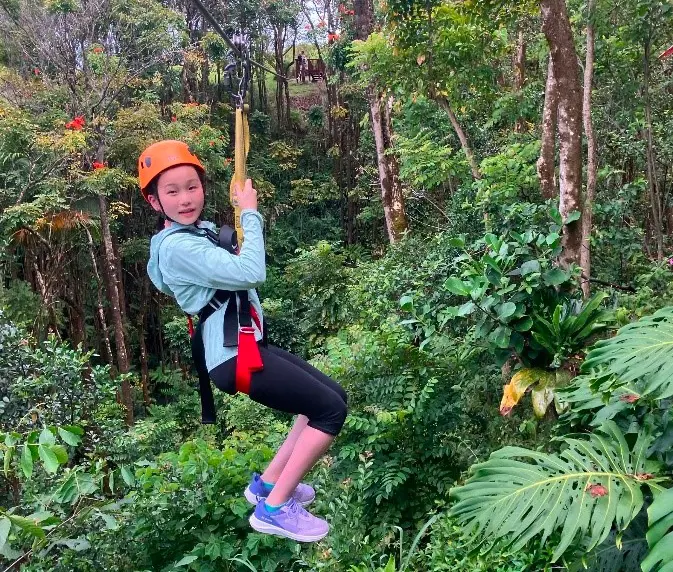 A young kid ziplining through the Hawaiian rainforest with Botanical World Adventures