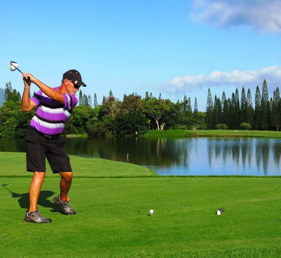 A golfer takes aim with a golf stick at the serene course at Princeville Makai Golf Club
