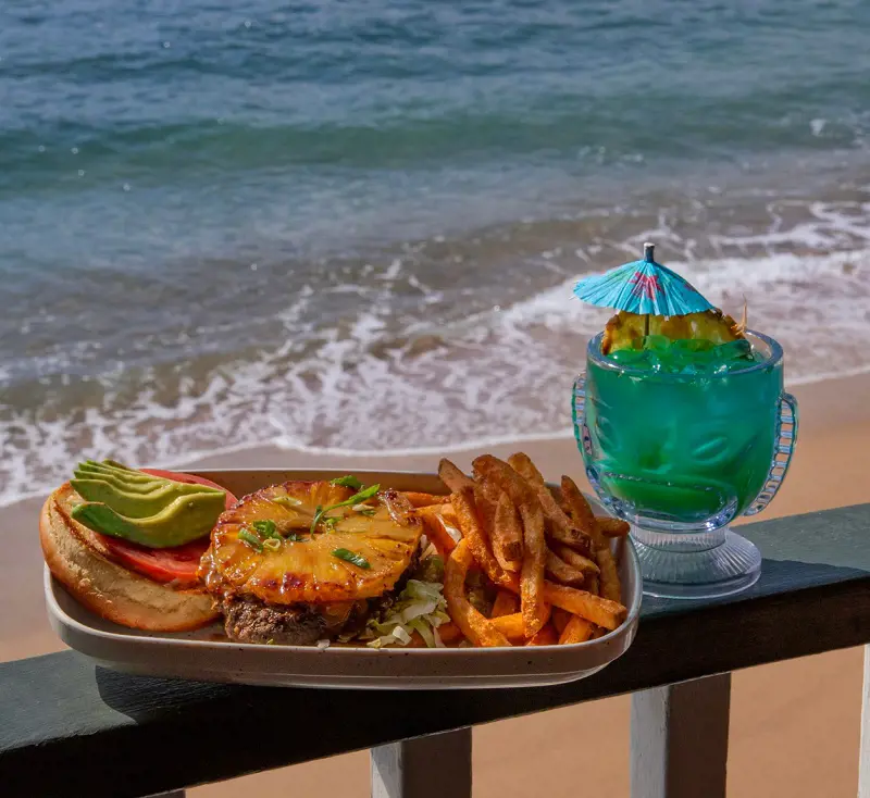 Enjoy a yummy Cheeseburger and a refreshing drink topped by the ocean view at Cheeseburger in Paradise, Maui