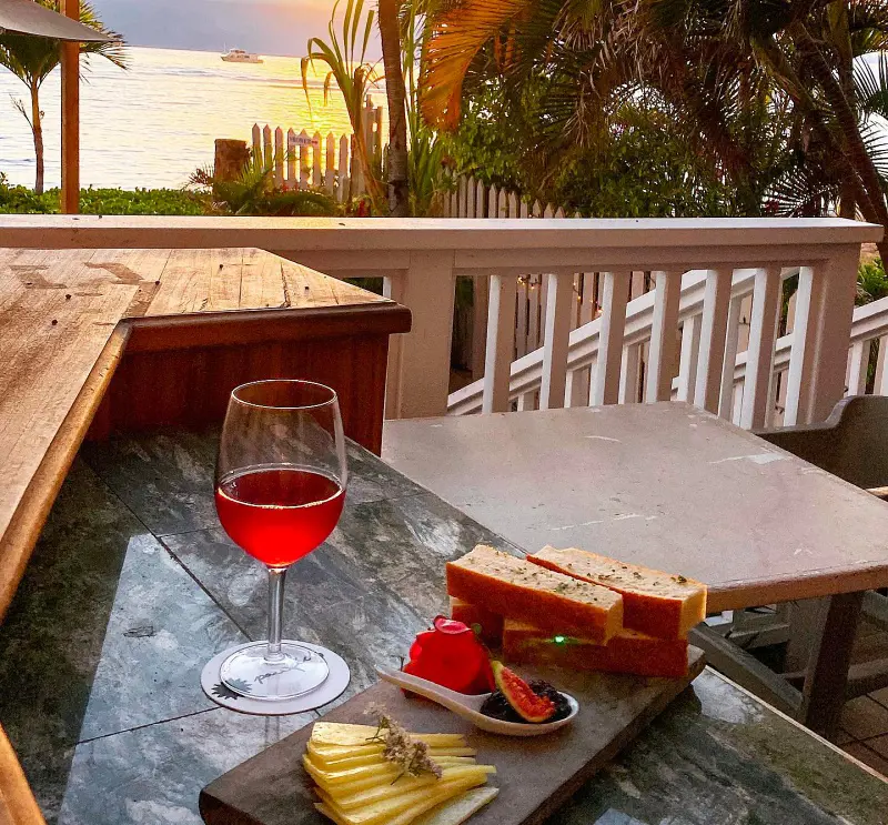 A cheese board and a cup of wine to start your meal with an amazing sunset view at Pacific'o On The Beach