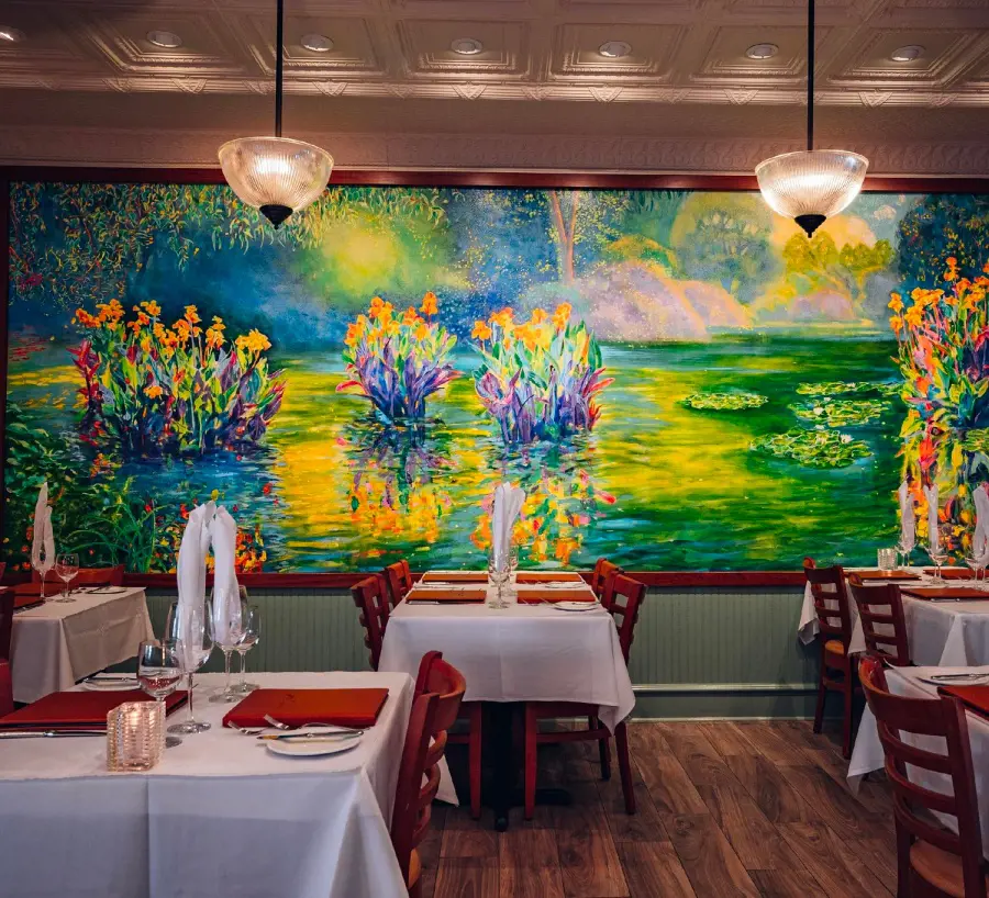 A lively and well-organized dining room at Lahaina Grill and a beautiful painting on the background